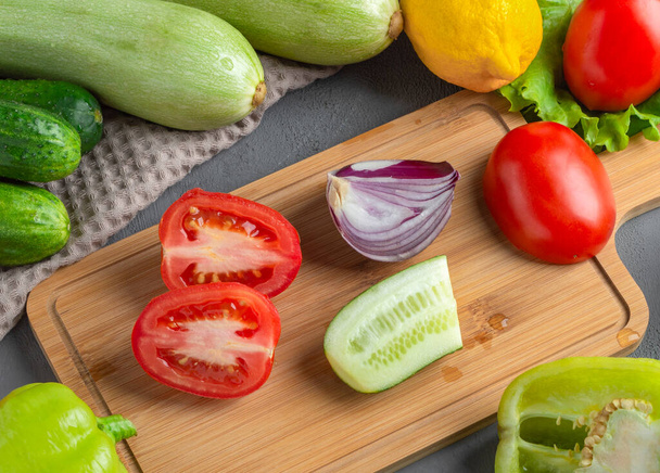 Verduras cruas frescas inteiras e cortadas em uma tábua. Alimentos saudáveis. - Foto, Imagem