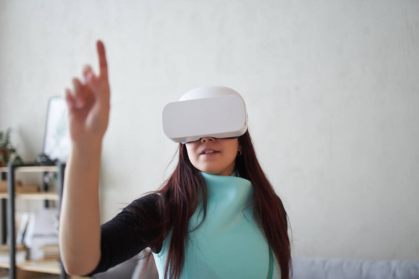 女性は仮想現実ヘッドセットを使用しています。仮想現実、ゲーム、未来技術の概念. - 写真・画像