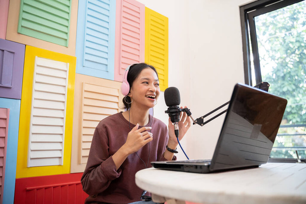Ein asiatischer Vlogger nimmt einen Podcast mit Mikrofon und Laptop auf - Foto, Bild