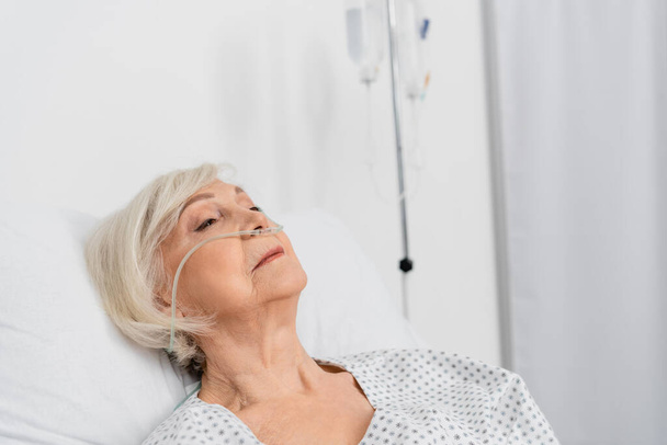 Älterer Patient mit Nasenkanüle liegt auf Krankenhausstation  - Foto, Bild
