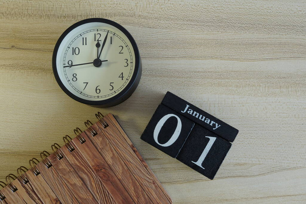 cube calendar with alarm clock on the wooden background - Foto, afbeelding