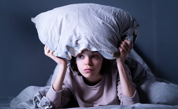 Женщина покрыта одеялом и беспокоится о бессоннице, испытывая стресс. - Фото, изображение