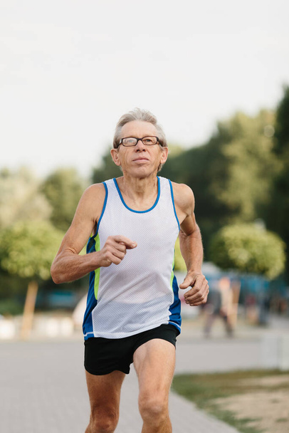 Μεγαλύτερος άνθρωπος ασχολείται με το τρέξιμο στον καθαρό αέρα. Υψηλής ποιότητας φωτογραφία - Φωτογραφία, εικόνα