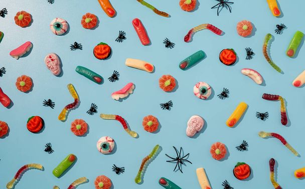Halloween concept. Colorful sweets for Halloween party on blue background, top view flat lay - Φωτογραφία, εικόνα