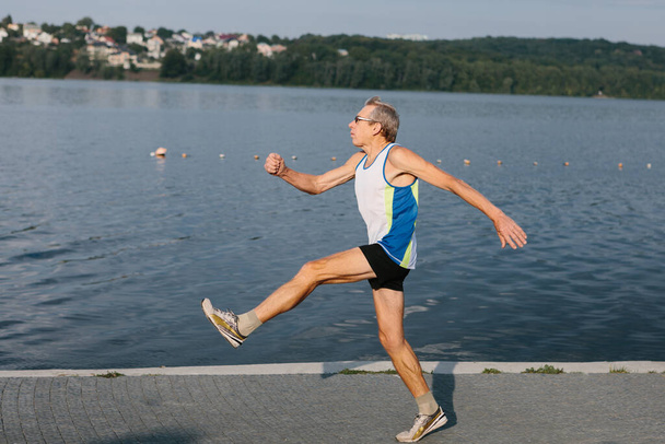 Μεγαλύτερος άνθρωπος ασχολείται με το τρέξιμο στον καθαρό αέρα. Υψηλής ποιότητας φωτογραφία - Φωτογραφία, εικόνα
