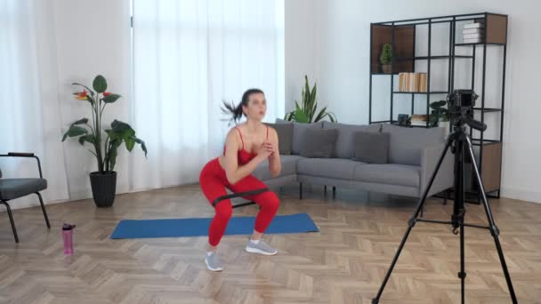 Sport musclé femme enregistre cours en ligne leçon sur caméra, entraînement à la maison - Séquence, vidéo