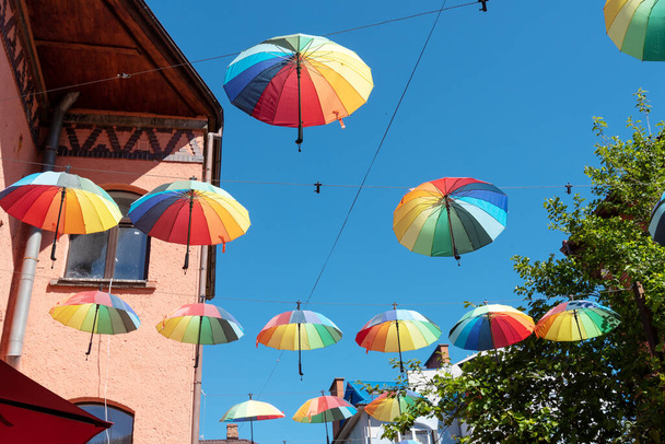 Gökyüzünde birçok renkli şemsiyeler var. Eğlence ve neşe kavramı. - Fotoğraf, Görsel