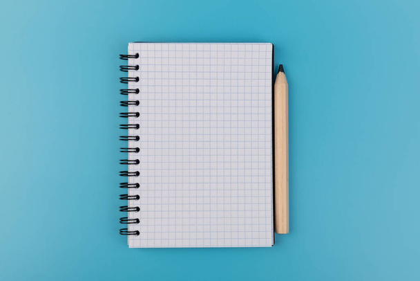 Bleistifte und leeres Notizbuch auf blauem Hintergrund mit Kopierraum - Foto, Bild
