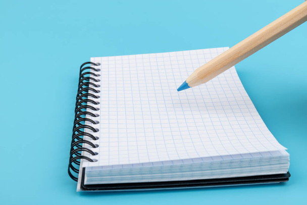 pencils and blank notebook on blue background with copy space - Photo, Image