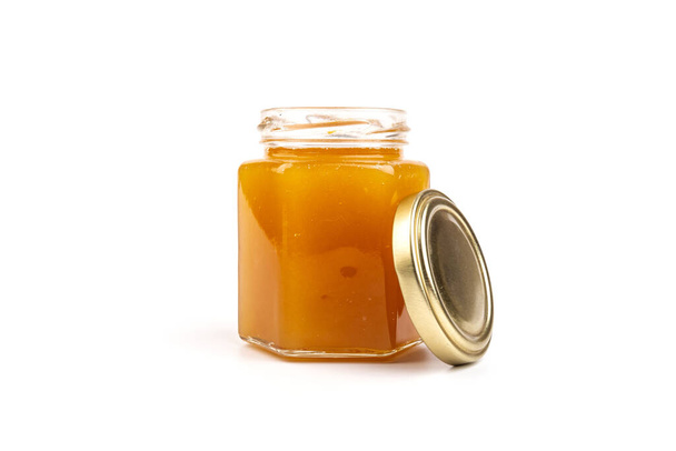 Honey in a glass jar close-up on a white. Isolated. - Zdjęcie, obraz