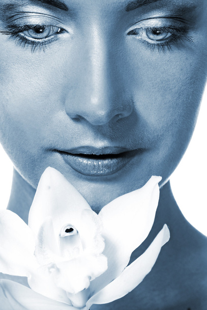 Detailní portrét krásné dívky s bílou orchidej (posílil v modrém) - Fotografie, Obrázek