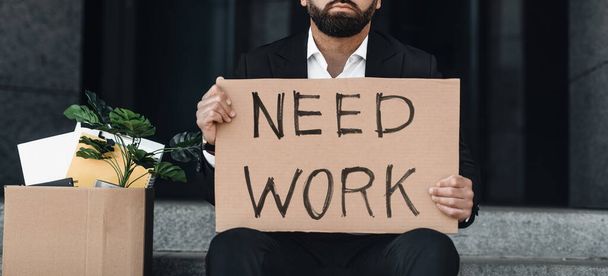 Безработица после закрытия. Неузнаваемый бизнесмен держит картонный знак с нужным рабочим текстом, урожаем - Фото, изображение