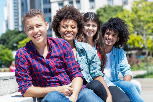 Group of multicultural young adults in a row outdoor in city in summer - Photo, image