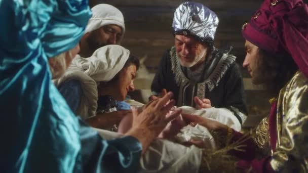 Magos y padres hablando sobre el pesebre con el bebé Jesús - Metraje, vídeo