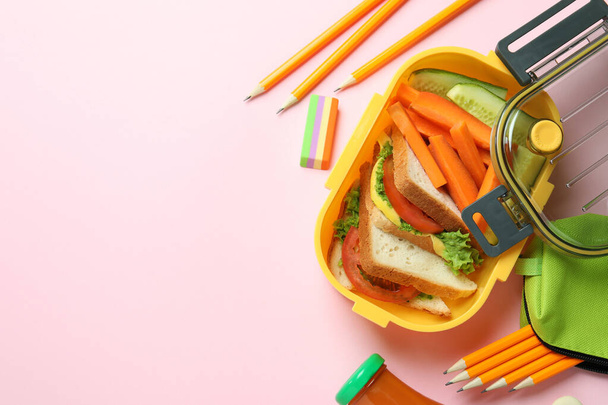 Caja de almuerzo con sabrosa comida sobre fondo rosa - Foto, Imagen
