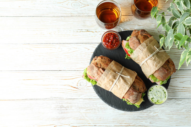 Концепция вкусной еды с бутербродами чаабатта на белом деревянном столе - Фото, изображение