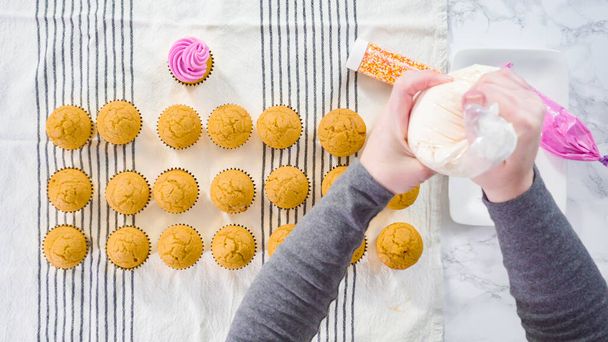 Pose plate. Piping crème au beurre italien glaçage sur le dessus de cupcake aux épices citrouille. - Photo, image