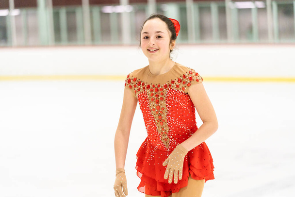 Teenage girl practicing figure skating on an indoor ice skating rink. - Photo, image