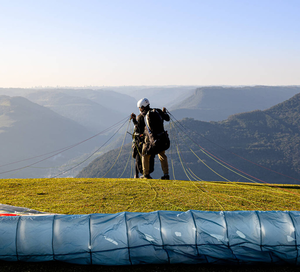 View from a paraglider in the Ninho das guias mountain range in Nova Petrpolis with people watching and recording the takeoff moment. Place used for panoramic flights with incredible natural beauty - Photo, Image