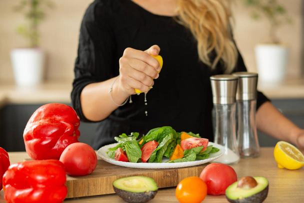 Подготовка салата в кухонном боксе, руки сожмите лимон, помидоры, кухня, авокадо - Фото, изображение
