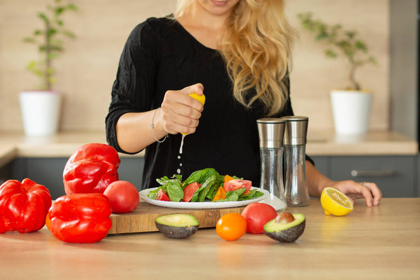 Подготовка салата в кухонном боксе, руки сожмите лимон, помидоры, кухня, авокадо - Фото, изображение
