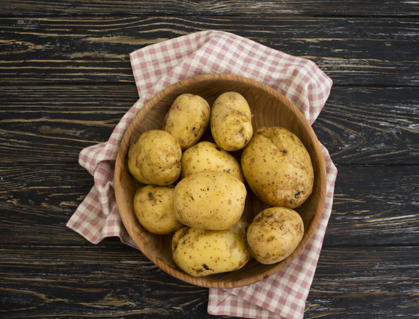 raw potatoes on wooden background  - Photo, Image