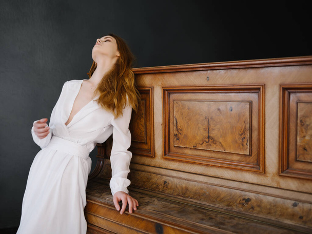 Mujer vestida de blanco por instrumento musical de piano  - Foto, imagen