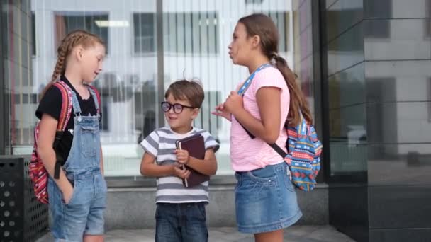  Três crianças com mochila ficar e conversar juntos  - Filmagem, Vídeo