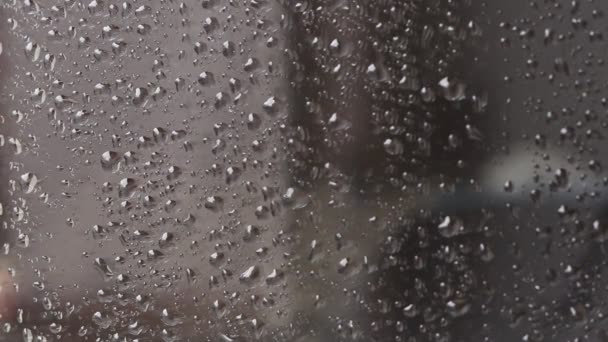 Esőcseppek az üvegen. Ablak egy esős napon. Csökkentse az üveget nagy mennyiségű vízzel vagy esővel. - Felvétel, videó