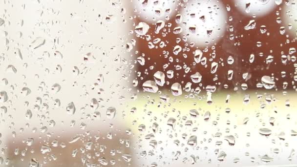 Gocce di pioggia su vetro. Finestra in un giorno di pioggia. Inumidire il vetro con grandi gocce d'acqua o pioggia. - Filmati, video