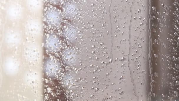 Des gouttes de pluie sur verre. Fenêtre un jour de pluie. Humidifier le verre avec de grandes gouttes d'eau ou de pluie. - Séquence, vidéo