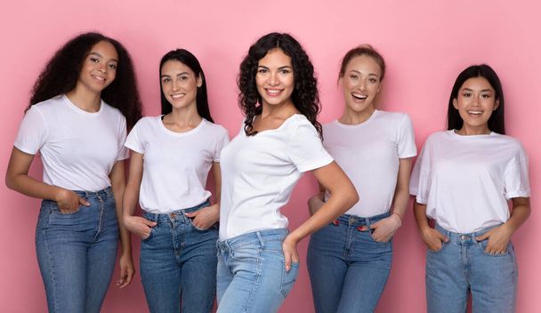 Latin Lady poseren met multi-etnische groep van vrouwen, roze achtergrond - Foto, afbeelding