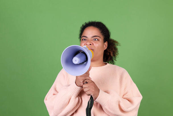 Mulher americana africana bonita no fundo verde gritando gritando em megafone pedir atenção - Foto, Imagem