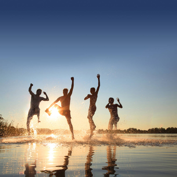 Gruppe junger Leute spielt an einem Sommertag am Sandstrand. - Foto, Bild