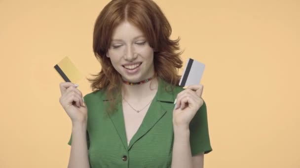 幸せな赤毛ティーン女の子保持クレジットカード孤立で黄色 - 映像、動画