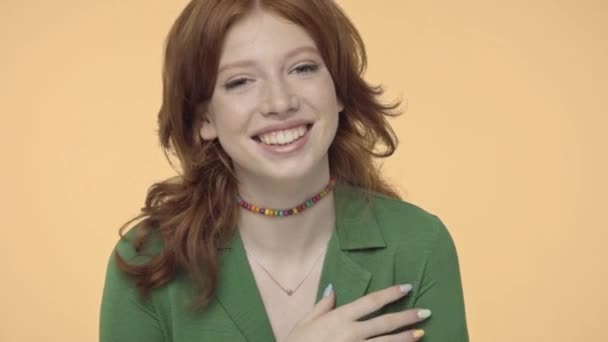 fröhliche Teenager-Mädchen mit roten Haaren lächeln isoliert auf gelb - Filmmaterial, Video