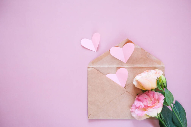 Creative minimal Valentine's Day concept. Envelope, valentines, white and pink heart confetti on a pastel pink background. Flat lay, top view, copy space - Φωτογραφία, εικόνα