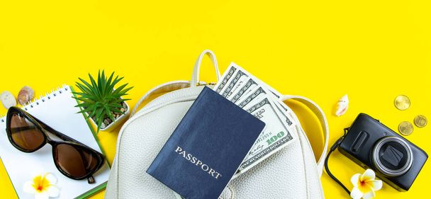 Yaz yolculuğu konsepti. Pasaport, para, güneş gözlüğü ve sarı arka planda bir kamera. Sancak biçimi, metin için yer. - Fotoğraf, Görsel