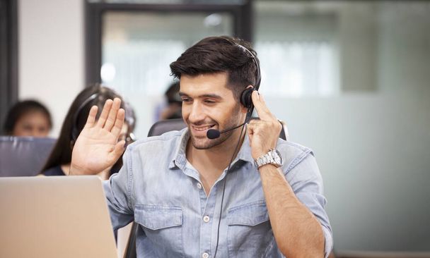 コールセンターで働く白人ビジネスマンは、 ITサポートサービスの顧客に挨拶するためにビデオ通話を使用しています - 写真・画像