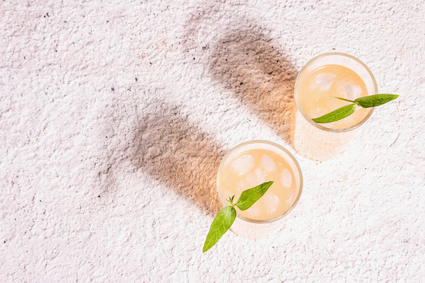 Sommer erfrischenden Cocktail. Kaltes süßes Getränk, modernes hartes Licht, dunkler Schatten. Kitt-Hintergrund, Draufsicht - Foto, Bild
