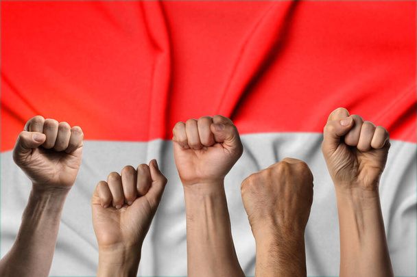 Sok kéz ököllel az indonéz zászló ellen. - Fotó, kép