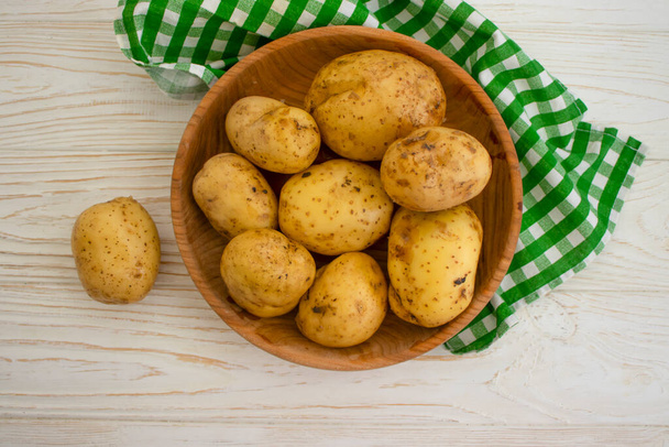 raw potatoes on wooden background  - Photo, Image
