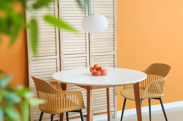 Jídelní stůl a skládací plátno v blízkosti barevné stěny - Fotografie, Obrázek