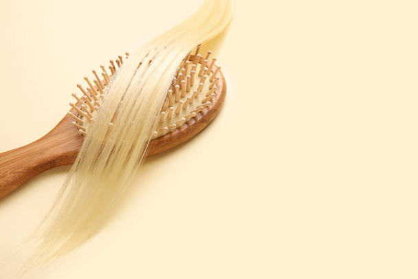 Wooden hair brush with strand on color background - Photo, Image