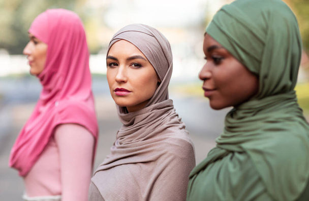 Груповий портрет трьох багаторасових ісламських жінок у хіджабі зовні
 - Фото, зображення