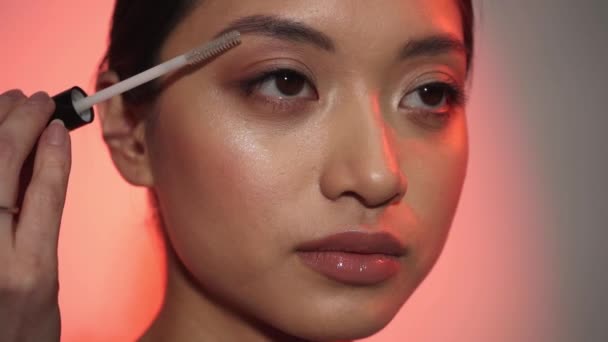 jovem asiático mulher styling sobrancelha no rosa - Filmagem, Vídeo