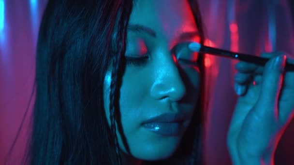 makeup artist εφαρμογή σκιά ματιών σε νεαρή ασιατική γυναίκα σε ροζ και μπλε - Πλάνα, βίντεο