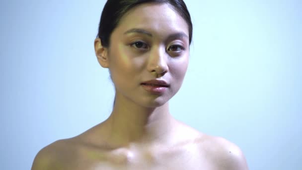 pretty asian woman with bare shoulders on blue - Footage, Video