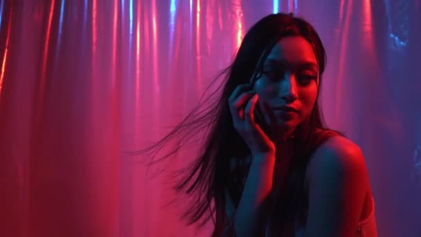 aziatische vrouw met glanzende huid poseren op roze en blauw  - Video