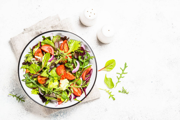 Green salad with fresh vegetables at white. - Fotoğraf, Görsel